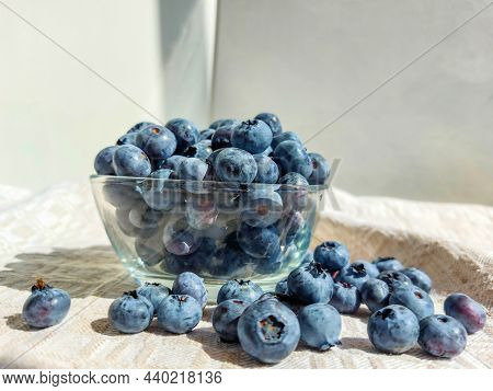 Close-up Shot Of Big, Ripe Cultivated Blueberries Or Highbush Blueberries In A Glass Bowl And On Tab