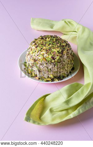 Sesame Halva With Pistachios On White Plate On Pink Background With Green Linen Napkin. High Angle V