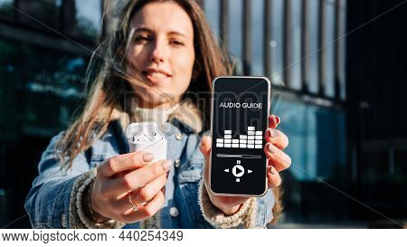 Audio Tour Online App On Digital Mobile Smartphone. Happy Young Student Woman Holding Phone Listenin
