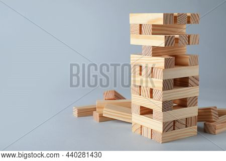 Jenga Tower Made Of Wooden Blocks On Grey Background, Space For Text