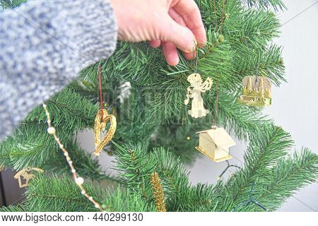Decorating The Christmas Tree, Holding Some Decoration In His Hand. Horizontal View Several Objects.