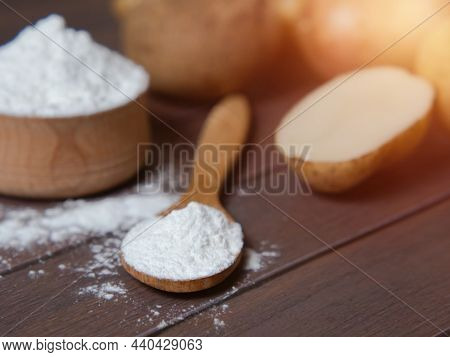 Potato Starch With Potatoes On A Dark Wooden Background.