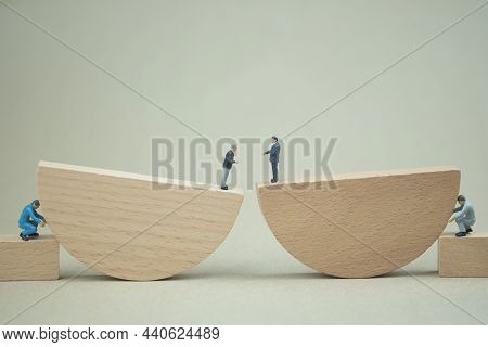 Miniature Workmen Push Round Wooden Blocks For Support Executive Standing On Top. The Concept Of Soc