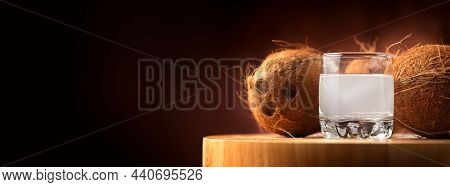 Coconut with coconuts water in a glass isolated on back background. Coconut milk. Border design. Wide screen. Fresh raw organic half of coco nut. Healthy Food, skin care concept. Vegan food