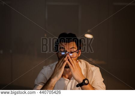 White puzzlement man with beard working in evening at office