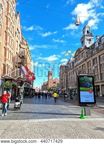 Amsterdam, The Netherlands - 03 October, 2021: People Walking In The Damrak Street. The Street Runs 