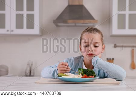 Cute Little Girl Refusing To Eat Dinner In Kitchen, Space For Text