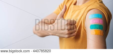 Woman Showing Thumb Sign With Bandage After Receiving Covid 19 Vaccine. Vaccination, Herd Immunity, 