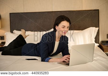 Beautiful Successful Young Caucasian Business Woman Relaxing After Work, Lying Down On A Bed In A Ho