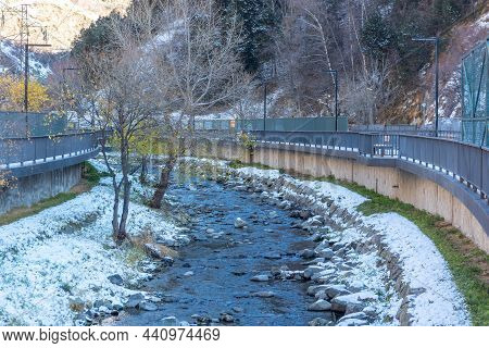 River Valira In Sunny Day With Snow On The Roofs Of The City Of Canillo In Andorra.