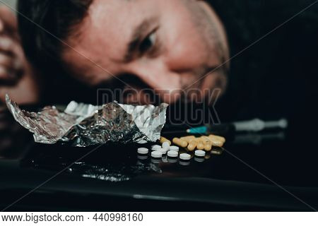 Drug Addict Looking At Drugs With Desire Or Overdose At Home Dark Living Room.toned.selective Focus.
