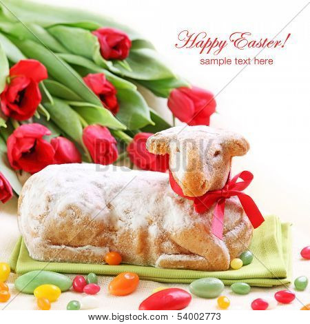 Easter lamb cake and red tulips on white background