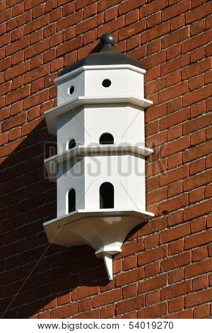 White Dovecote on red brick wall
