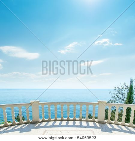 white balcony near sea and light clouds on sky