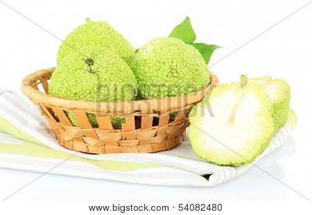 Osage Orange fruits (Maclura pomifera) in basket, isolated on white