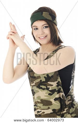 A beautiful teen girl happily looking at the viewer as she forms a gun with upraised hands.  On a white background.