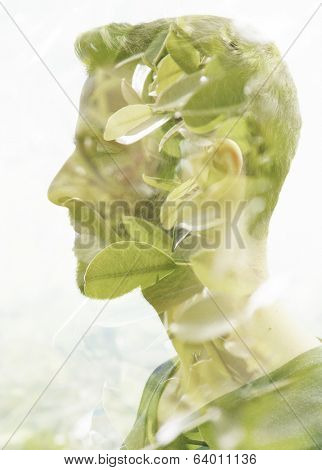Double exposure portrait of young man and green leaves