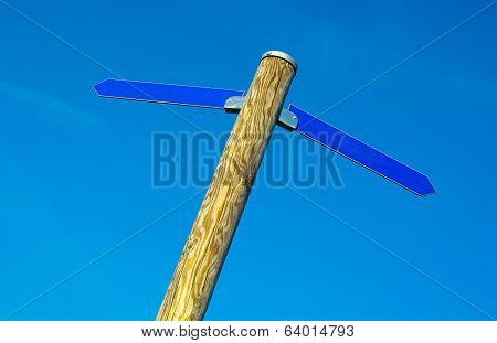 Wooden pole with two blue direction arrows