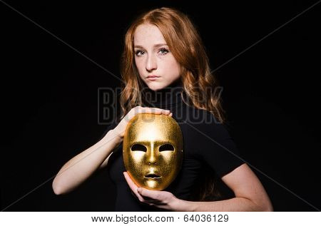 Redhead woman iwith mask in hypocrisy consept against black  background