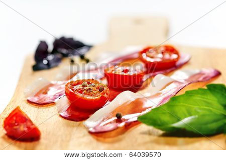 Dried Cherry Tomatoes With Bacon Served On Carving Board. Selective Focus.