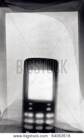 Phone on photo paper photogram. Image contains dust and grain.