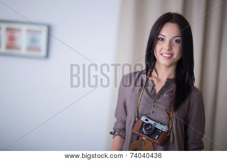 Woman is a proffessional photographer with camera in office