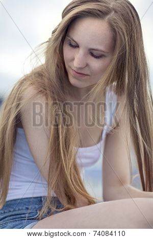 Thinking young model woman sitting outdoor
