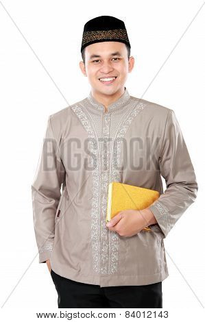 Young Muslim Man Carrying The Quran