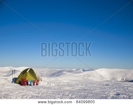 Snowshoes And Tent On Snow In The Mountains.
