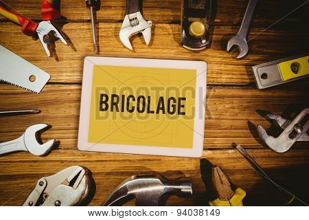 The word bricolage and tablet pc against blueprint