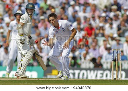 LONDON, ENGLAND - August 21 2013: Chris Woakes fields the ball off his own bowling as Chris Rogers looks on during day one of the 5th Investec Ashes cricket match between England and Australia