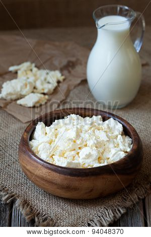 Homemade traditional cottage cheese ogranic dairy product with milk in rustic wooden dish on vintage
