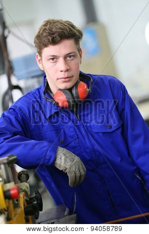 Portrait of plumber apprentice standing in workshop