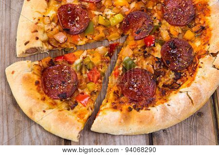 Delicious Baked Salami Pizza Served On Rustic Wooden Table