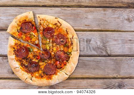 Delicious Baked Salami Pizza Served On Rustic Wooden Table