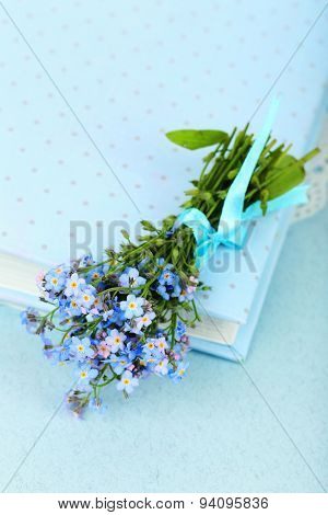 Forget-me-nots flowers on book, on blue background