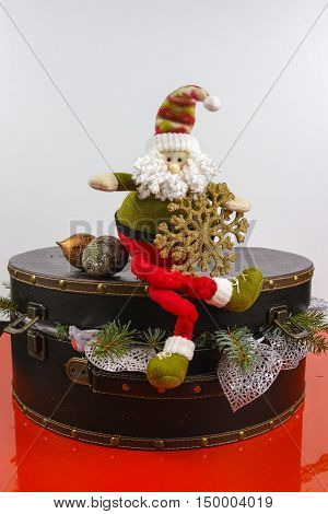 Santa Claus sits on vintage brown coffer with white Christmas tree decoration copy space