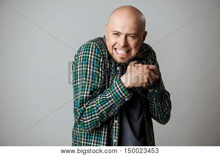 Vicious emotional man in shirt posing over beige background. Copy space.