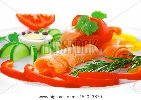 smoked salmon slices with vegetabls over white plate