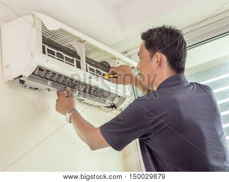 Single electrician man clean fix and maintain air conditioning in the house