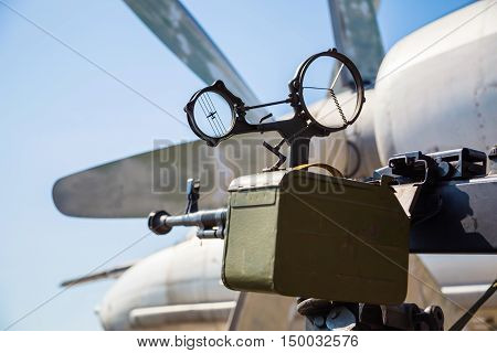 Retro gun on the tripod and optical sight, against the backdrop of the aircraft propellers, close-up. Machine gun outdoors.