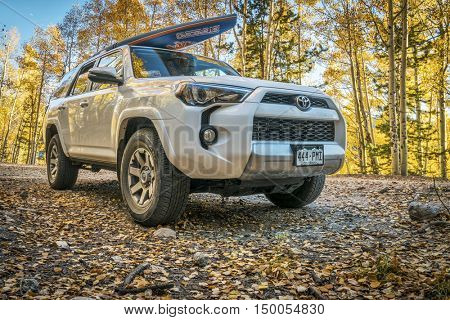 BASALT, CO, USA - SEPTEMBER 27, 2016: Toyota 4Runner SUV (2016 Trail edition) carrying  a paddleboard on Frying Pan Road with fall colors in Colorado's Rocky Mountains