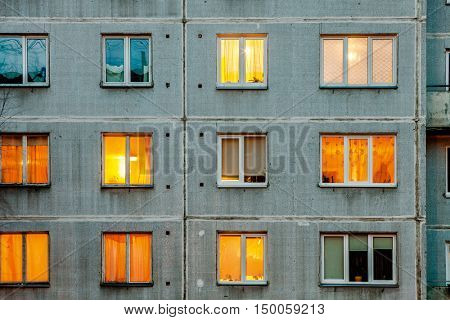 Wall with iIluminated windows. Detail of soviet era block apartment building