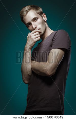 Handsome Man In Black T-shirt Posing On Blue Background. Model Tests