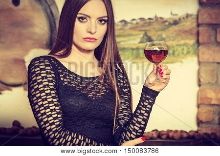 Woman Tasting Wine In Rural Cottage Interior