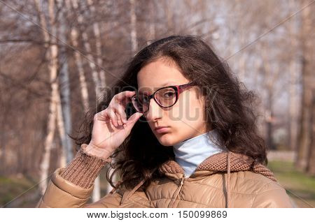 Portrait of a girl with glasses in the park