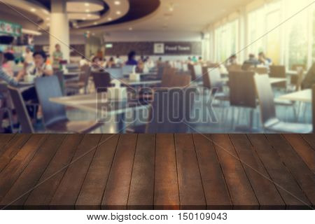 wooden table mock up interior restaurant design advertising food court with wooden table texture background empty table ready for product display montage over blurred food court background.