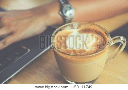coffee cup on wood table with labtop office space