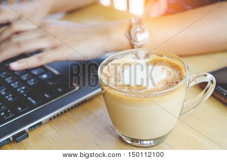 coffee cup on wood table with labtop office space