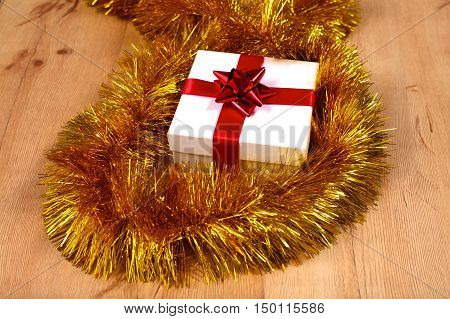 New Year gift on a golden tinsel background boly.
